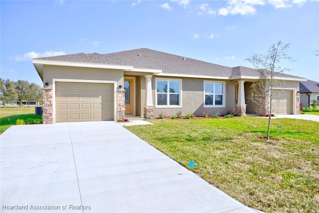 view of front of house with a garage, central AC, and a front lawn