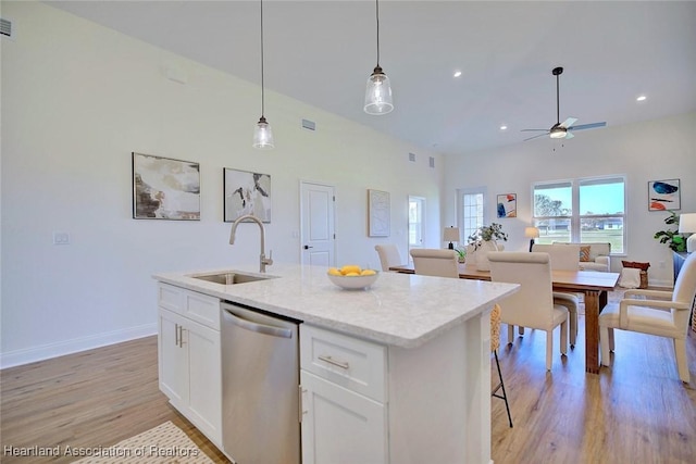 kitchen with white cabinets, an island with sink, sink, hanging light fixtures, and stainless steel dishwasher