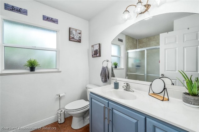 bathroom featuring a wealth of natural light, toilet, a shower stall, and vanity