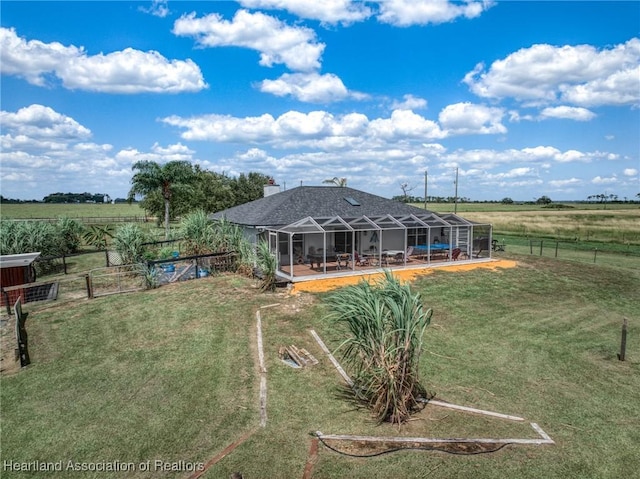 view of yard featuring a lanai, fence, and a rural view