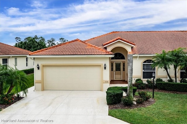 mediterranean / spanish home with a front yard and a garage