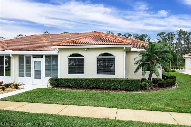 mediterranean / spanish-style home featuring a sunroom and a front yard