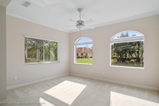 carpeted empty room with ceiling fan and crown molding