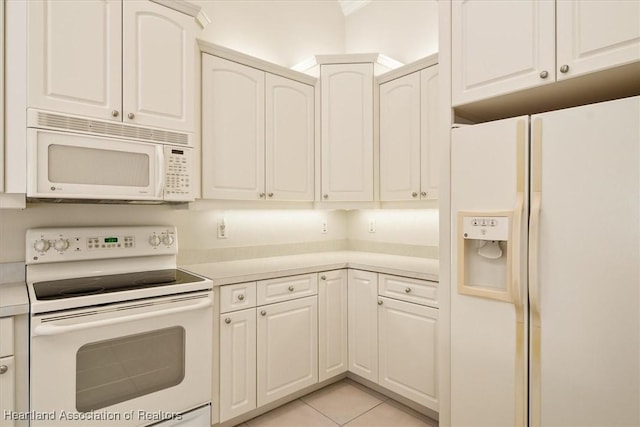 kitchen with white cabinets, white appliances, and light tile patterned floors