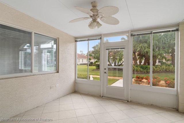 unfurnished sunroom with ceiling fan