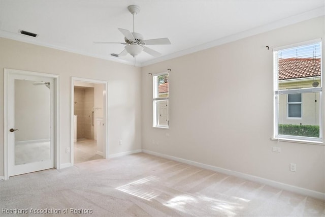 unfurnished bedroom with ceiling fan, ensuite bathroom, ornamental molding, and light carpet