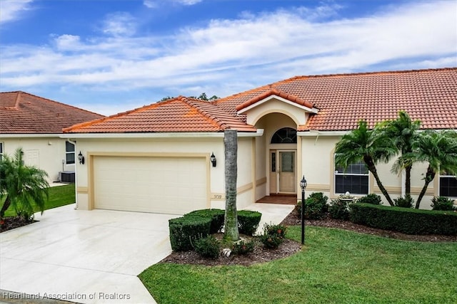 mediterranean / spanish home with a garage and a front lawn