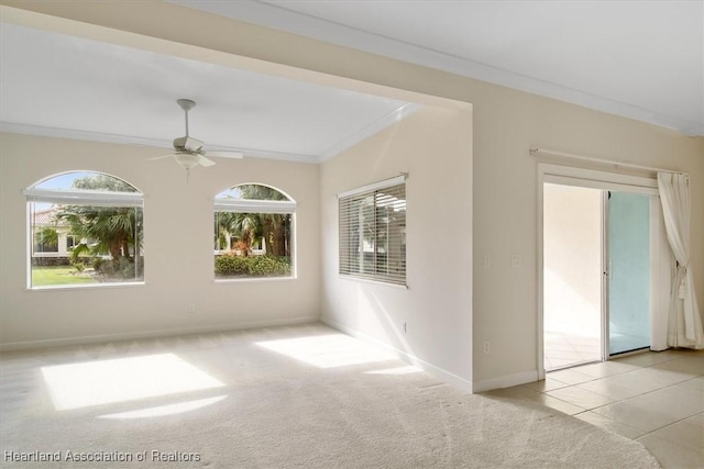 spare room featuring ceiling fan, crown molding, and light carpet