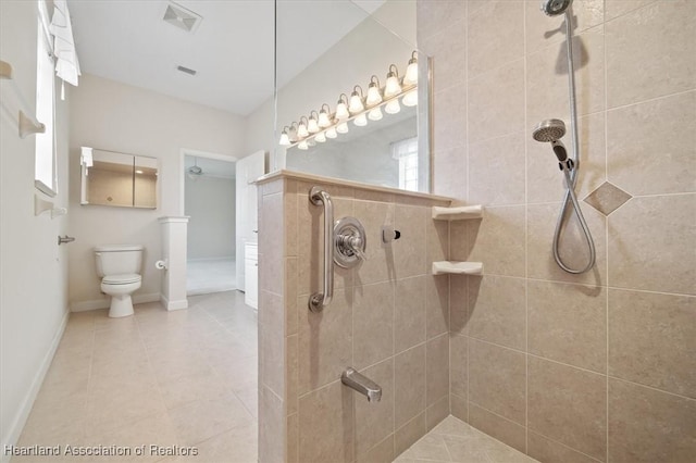 bathroom featuring a tile shower and toilet