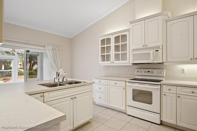 kitchen with sink, light tile patterned floors, vaulted ceiling, white appliances, and white cabinets