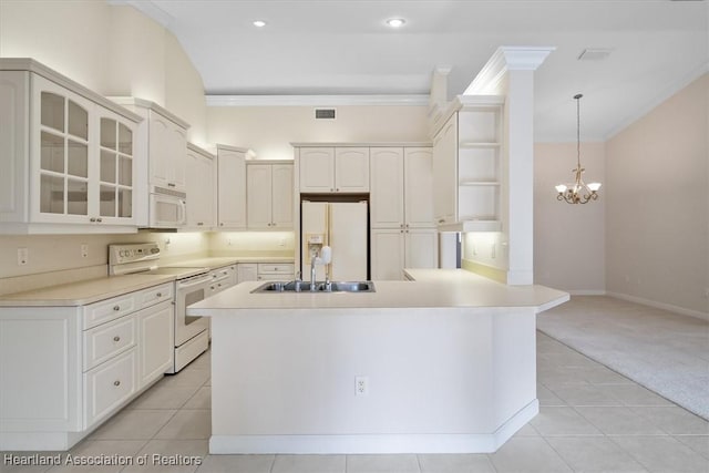 kitchen with white appliances, light carpet, white cabinets, hanging light fixtures, and a chandelier