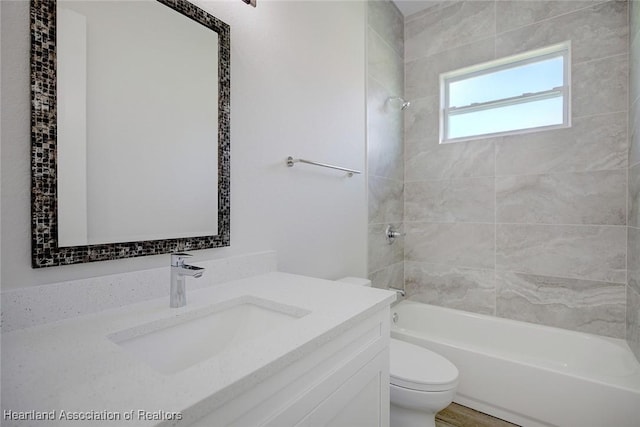 full bathroom with vanity, tiled shower / bath combo, and toilet