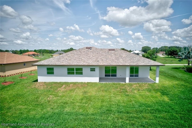 rear view of house featuring a lawn and a patio area