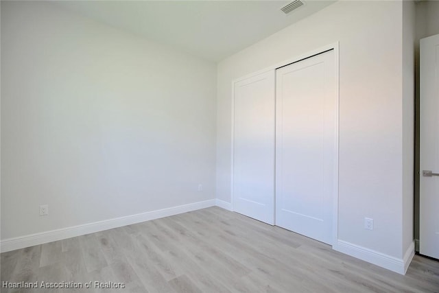 unfurnished bedroom featuring light wood-type flooring and a closet