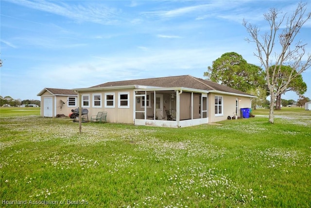 rear view of property with a sunroom and a yard