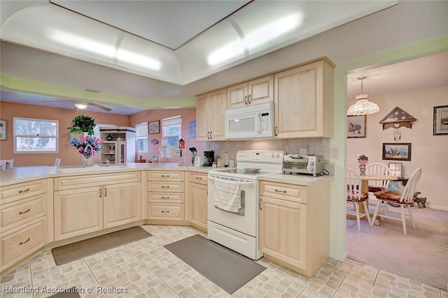 kitchen with white appliances, sink, hanging light fixtures, decorative backsplash, and ceiling fan