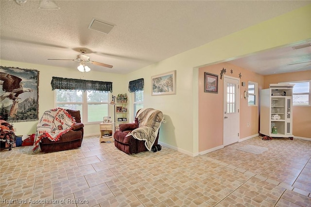 sitting room featuring a textured ceiling, a wealth of natural light, and ceiling fan