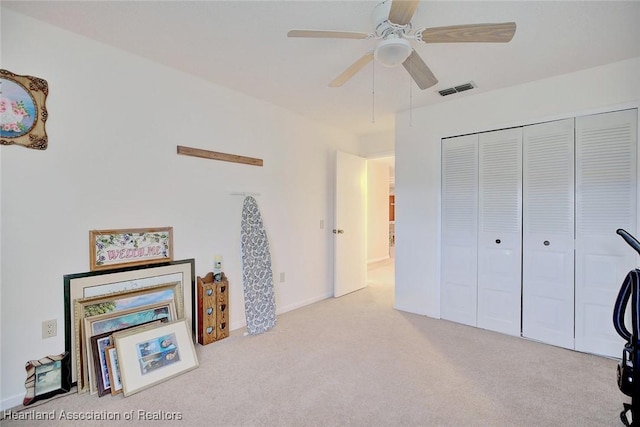 interior space with light colored carpet and ceiling fan