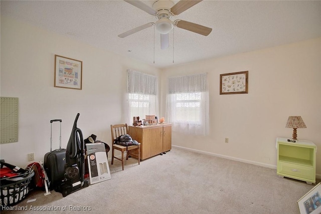 miscellaneous room with ceiling fan, light colored carpet, and a textured ceiling