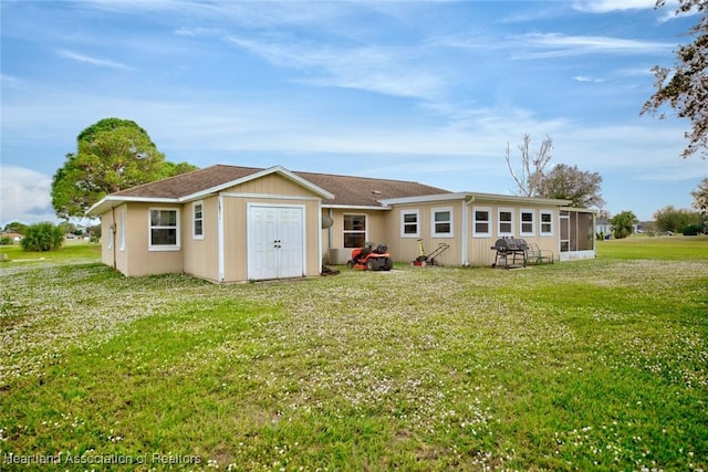 back of house featuring a lawn and a sunroom