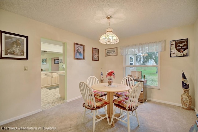 carpeted dining room with a textured ceiling and a chandelier