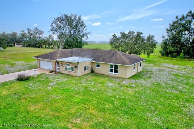 view of front of home with a rural view, a garage, and a front lawn