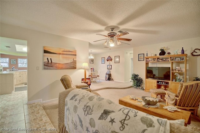 living room with ceiling fan and a textured ceiling