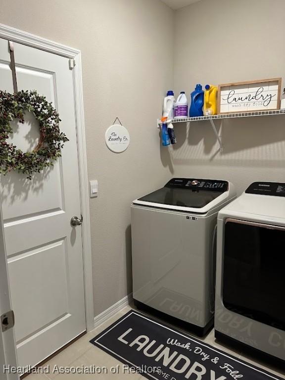 washroom with washing machine and dryer and light tile patterned floors