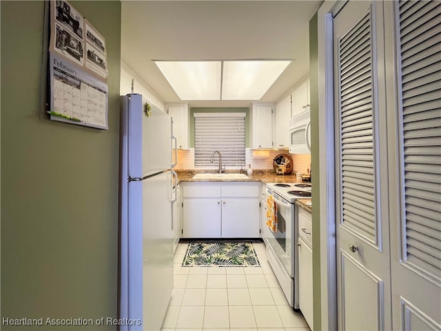 kitchen featuring light tile patterned floors, white appliances, white cabinetry, and sink