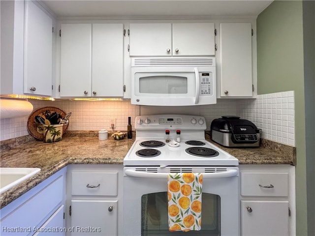 kitchen featuring white appliances, tasteful backsplash, and white cabinetry