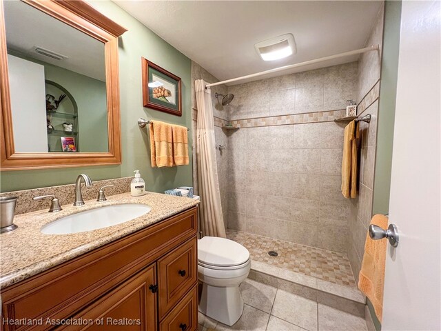 bathroom featuring tile patterned flooring, vanity, a shower with shower curtain, and toilet