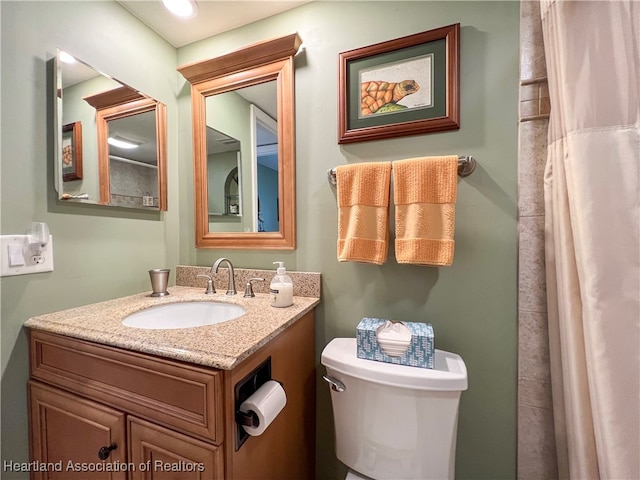 bathroom featuring a shower with curtain, vanity, and toilet