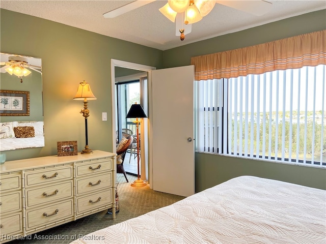 carpeted bedroom featuring a textured ceiling and ceiling fan