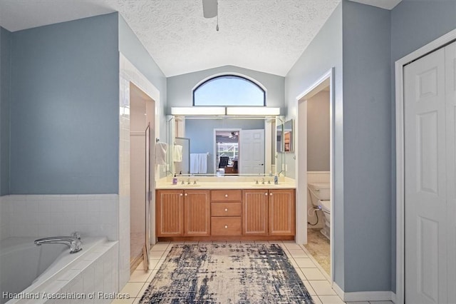 bathroom featuring tile patterned flooring, tiled bath, a textured ceiling, vaulted ceiling, and toilet