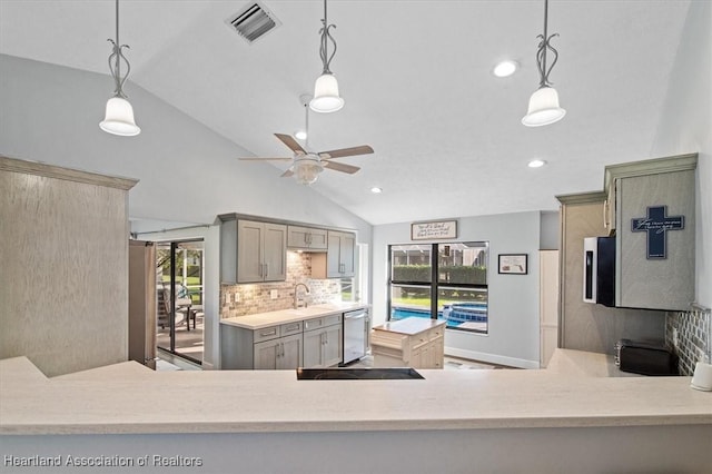 kitchen featuring backsplash, vaulted ceiling, hanging light fixtures, and sink