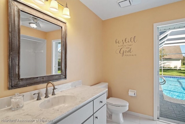 bathroom with toilet, a shower, vanity, and tile patterned floors