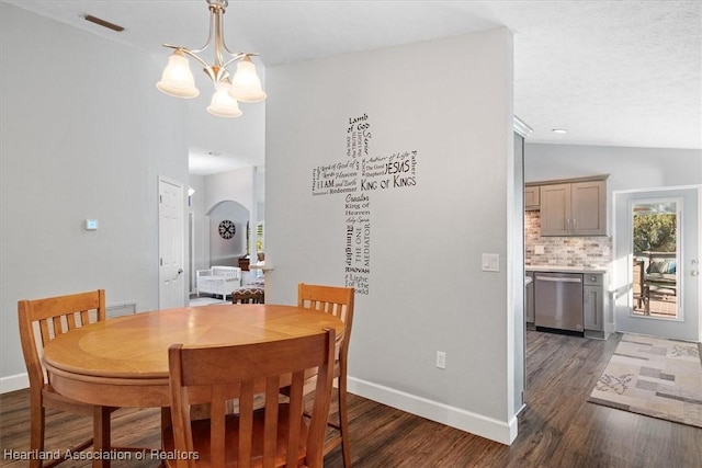 dining area featuring a notable chandelier, lofted ceiling, and dark wood-type flooring