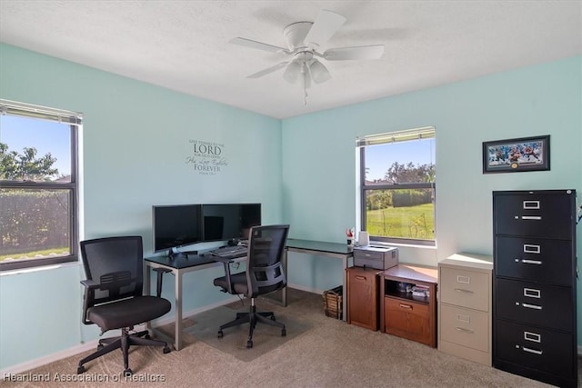 carpeted office space featuring ceiling fan