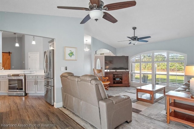 living room with ceiling fan, light wood-type flooring, and vaulted ceiling