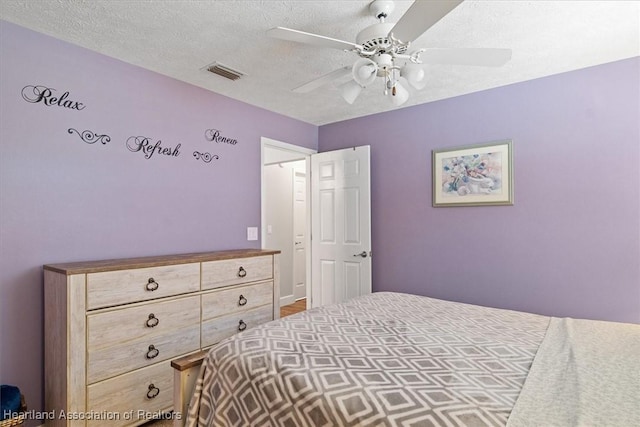 bedroom with a textured ceiling and ceiling fan