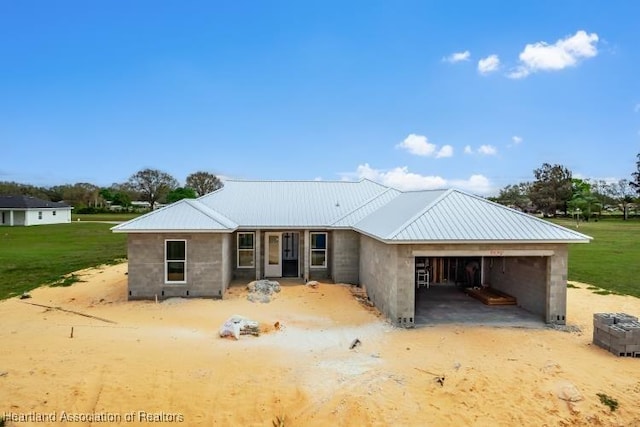 view of front of property with a garage, metal roof, and a front lawn