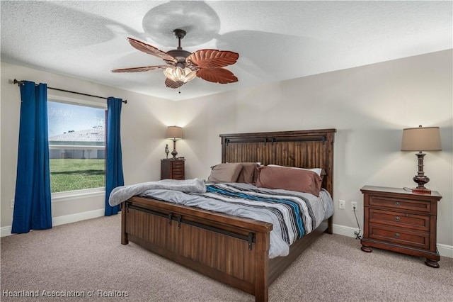 carpeted bedroom with ceiling fan and a textured ceiling