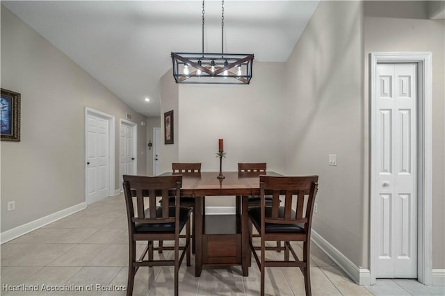 tiled dining area with a chandelier and vaulted ceiling