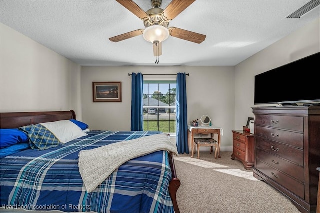 carpeted bedroom featuring a textured ceiling and ceiling fan