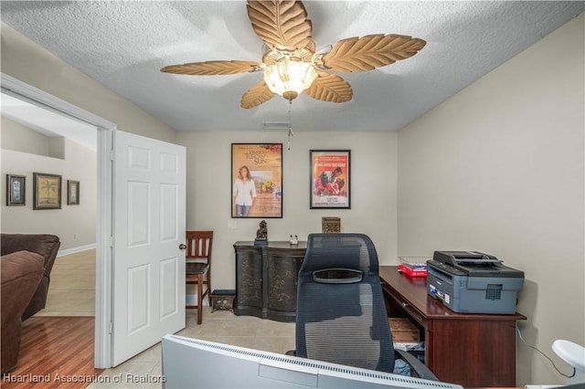 tiled office featuring a textured ceiling and ceiling fan