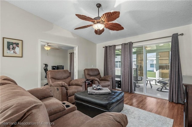 living room featuring a textured ceiling, hardwood / wood-style flooring, ceiling fan, and lofted ceiling