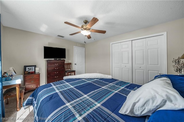 bedroom featuring carpet flooring, ceiling fan, a textured ceiling, and a closet