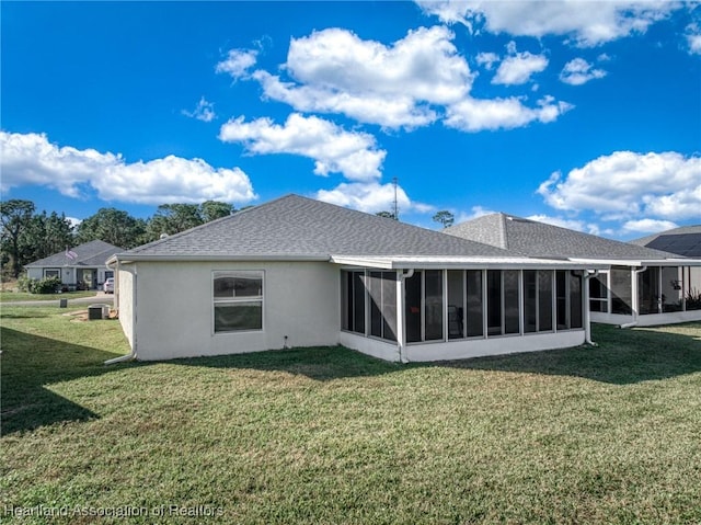 back of property featuring a sunroom, central air condition unit, and a lawn