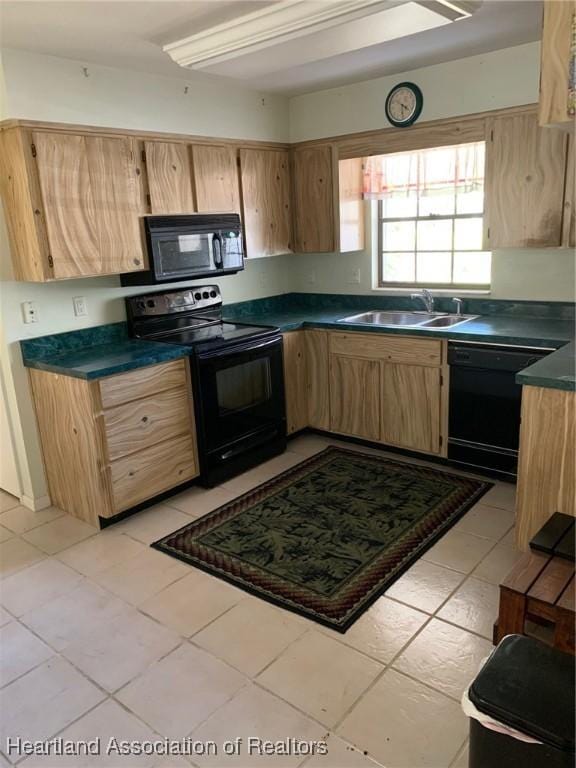 kitchen featuring light brown cabinetry, dark countertops, a sink, light tile patterned floors, and black appliances