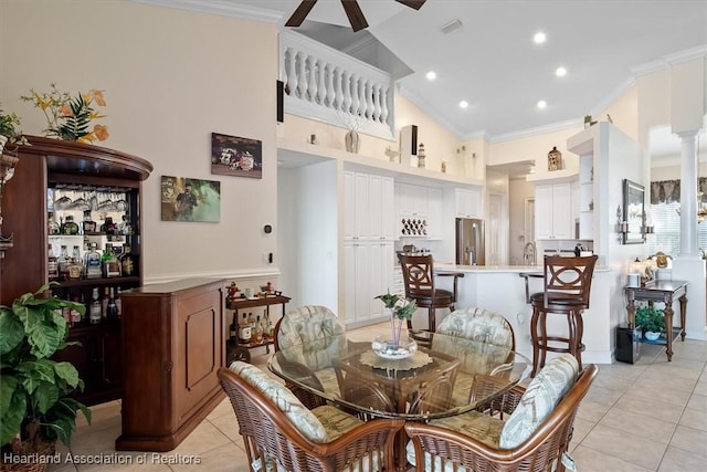 tiled dining area with ornamental molding, ceiling fan, lofted ceiling, and sink